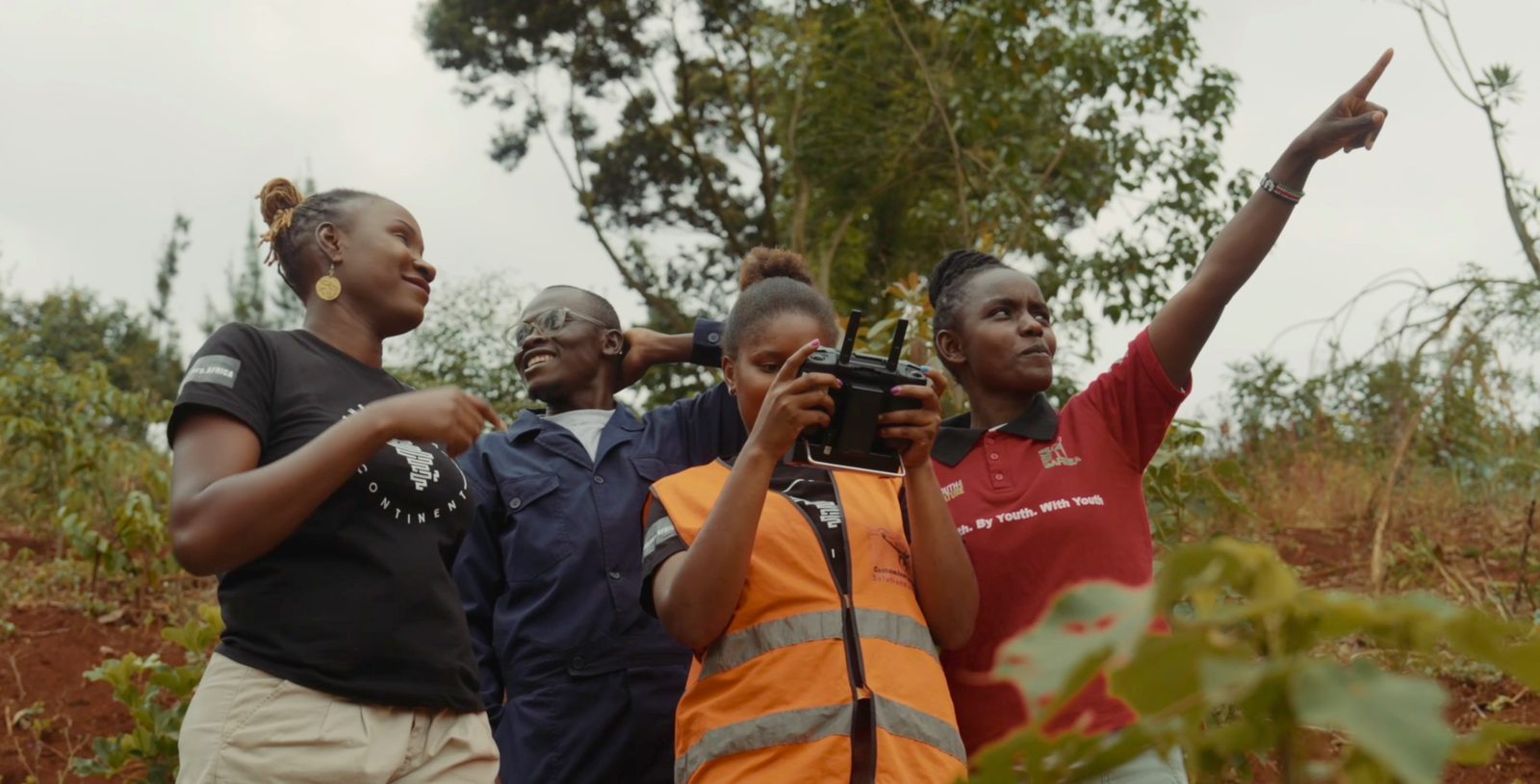 Four africanDRONE pilots at the Ondiri wetlands, near Nairobi, one pointing at the sky